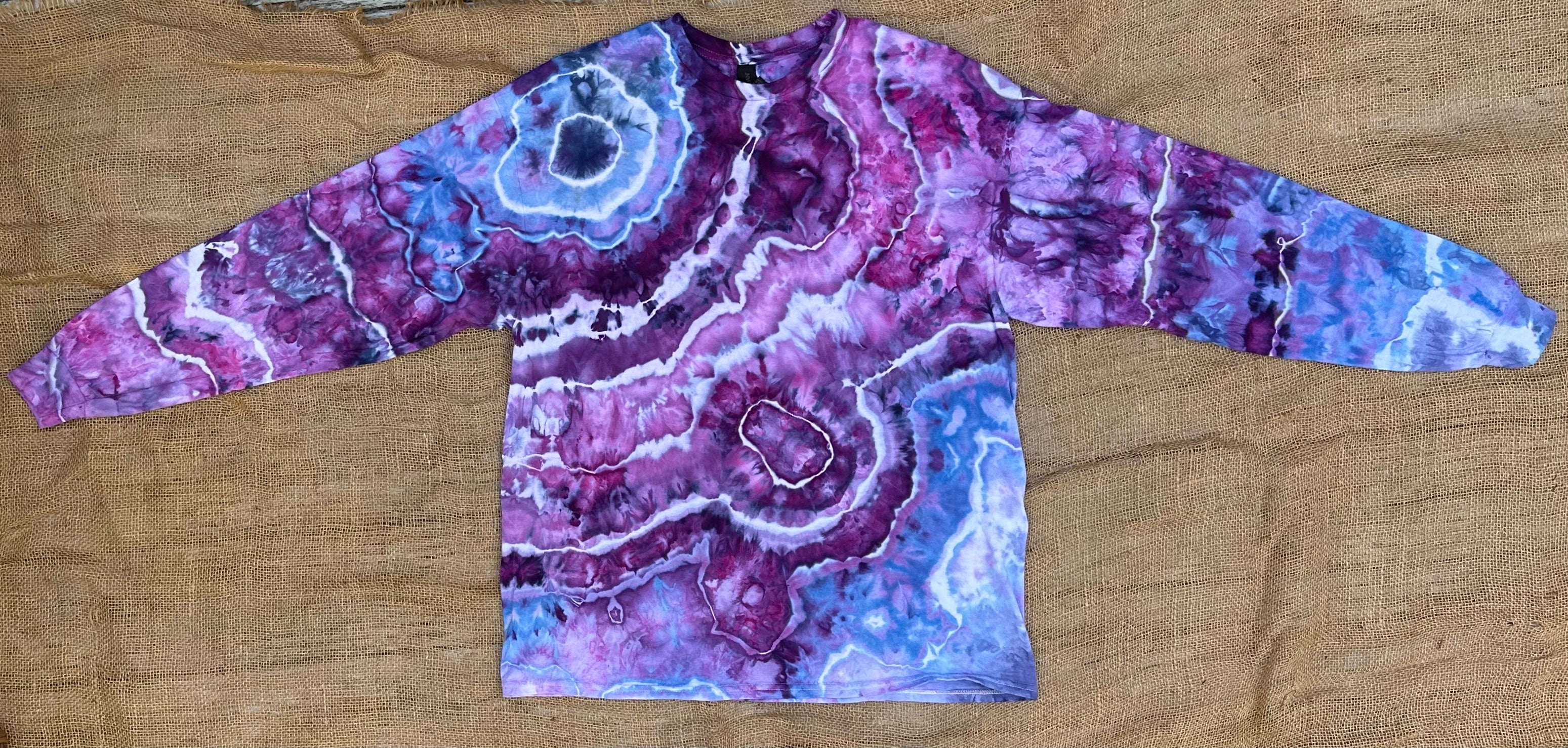 Marbled purple and blue long-sleeve shirt on a canvas surface